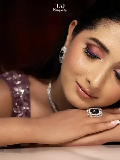 A close-up beauty shot of a bride, highlighting her flawless makeup and the intricate details of her jewelry. The tattoo on her arm adds a personal touch.