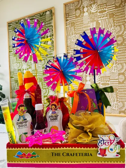 A full view of the nostalgic Holi hamper. It's a burst of joy, featuring a sweet box wrapped in organza, a potli of dry fruits, thandai, sherbet, and fun quirky glasses, all packed into a festive tray that screams 'Holi Hai!'.
