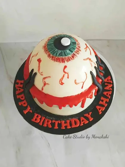 A creepy and cool monster eye themed cake for a Halloween birthday. This unique design is perfect for someone who loves all things spooky.