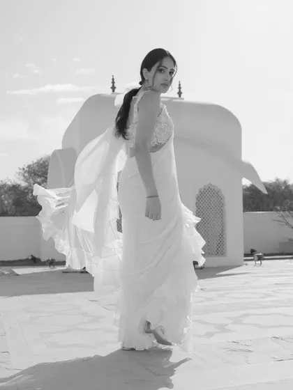A dynamic black and white shot of Sandy, her ruffled saree catching the wind, creating a sense of movement and freedom.