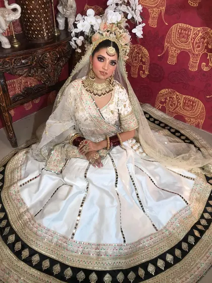 A full-circle view of the white Anarkali lehenga, showcasing its beautiful flare and the intricate details on the border.