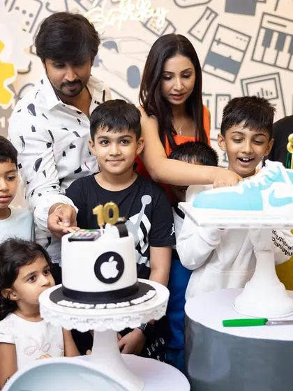 The birthday boys cutting their custom Apple and Nike-themed cakes at their joint celebration.