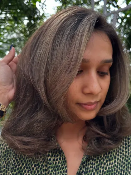 A portrait of a client with her ash-highlighted holiday hair.