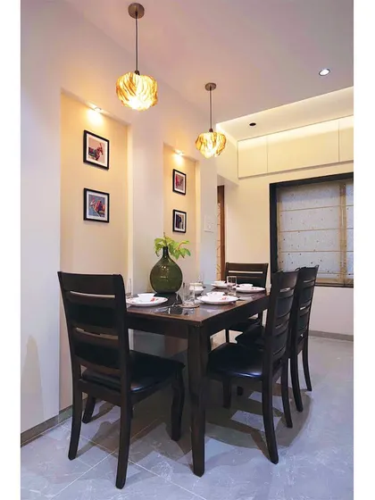 We believe in giving new life to old treasures. This client's existing wooden dining set was seamlessly integrated into the new design, complemented by modern pendant lights and wall niches for family photos.