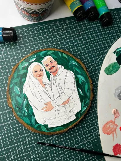 A work-in-progress shot of a customized cartoon illustration on a wooden panel. These make for cute and budget-friendly gifts.