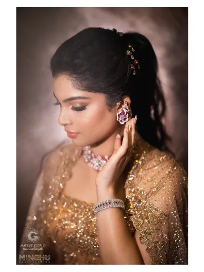 A detailed shot of Sindhu's makeup and jewelry. The soft gold and brown tones on her eyes complement the warmth of her outfit, while her skin looks luminous and flawless.
