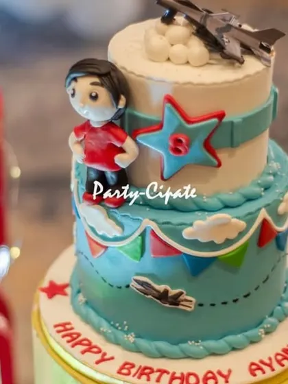 A close-up of the fighter jet cake. The cake topper features a cartoon pilot and jet, perfectly capturing the fun and adventurous spirit of the party.
