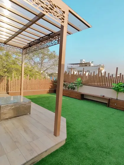 A wide shot showing how the pergola sits within the larger terrace space. It provides a focal point and a functional shaded area without overwhelming the open feel of the rooftop.