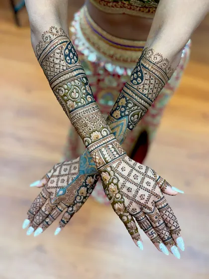 A unique bridal design with a beautiful blend of colors, showing the fresh henna paste alongside the developing stain.