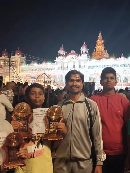 A memorable photo with my students and their trophies in front of the beautifully illuminated Mysore Palace during the Dasara Karate Championship.