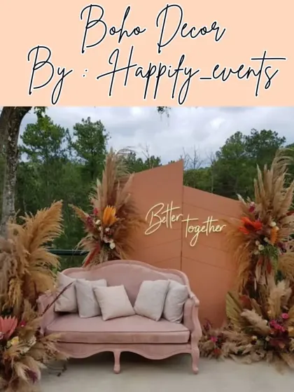 Showcasing a popular boho-themed decor style, perfect for outdoor engagements or anniversary celebrations. This setup features pampas grass, dried palm leaves, and a rustic color palette, complete with a comfortable vintage sofa and a "Better Together" sign.