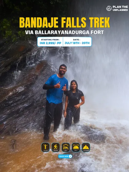 Two trekkers enjoying the powerful spray of a waterfall on the Bandaje trek. It's an experience that truly awakens the senses.