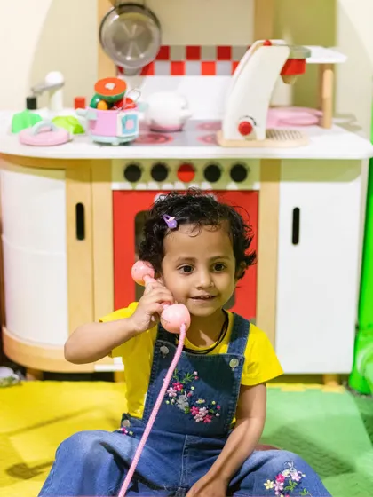 This little one is taking calls and running her own business from our play kitchen area.