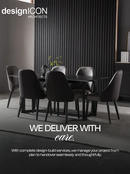 A sleek dining or meeting area with a dark table and chairs against a black fluted wall. This image represents our commitment to delivering with care, managing every detail of the design-build process from plan to handover.