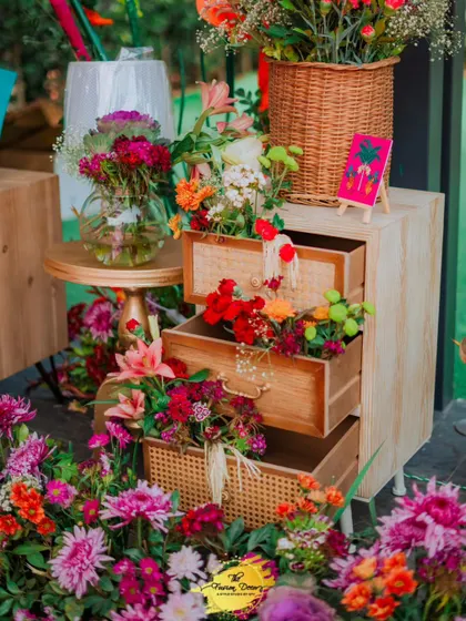 Flowers, flowers, and more flowers! This decor piece features a vintage-style cabinet with drawers overflowing with a vibrant mix of real flowers, adding a touch of rustic charm and abundant beauty.