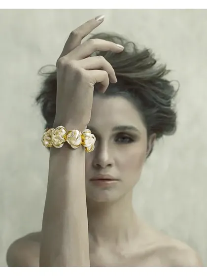Another piece from the "Sculptured Portraits" series, this time focusing on a floral-inspired gold bracelet. The painterly texture and soft light give the image a timeless, artistic quality.