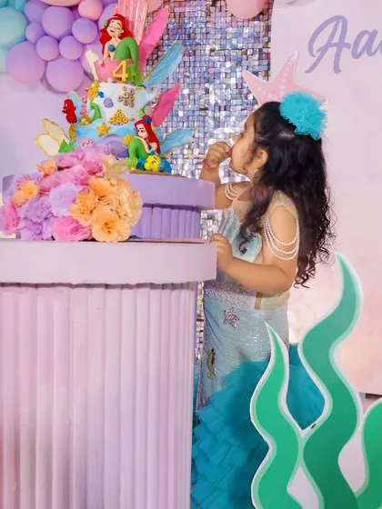 The birthday girl enjoying a piece of her magnificent Little Mermaid cake. We focus on creating moments of pure joy.