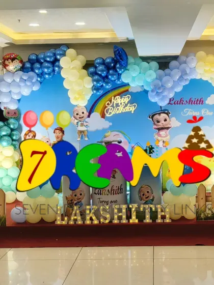 Another large-scale Cocomelon decoration. This one features a school bus prop, multiple character cutouts, and a sky-themed backdrop with a full balloon arch.
