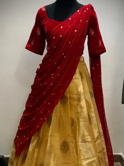 A mannequin shot of the red and gold half saree.