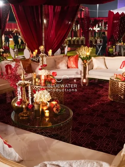 Inside the luxurious red lounge, where guests can relax on plush sofas surrounded by candlelight and beautiful floral details.