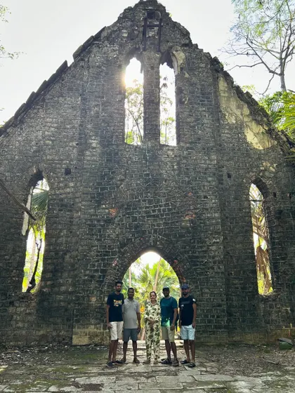 Our group posing in front of the dilapidated church on Ross Island, with the sun shining through the empty windows.