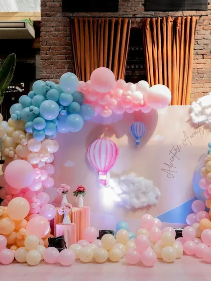 A full view of the 'Up, Up & Away' hot air balloon themed baby shower. The pastel balloon clouds and backdrop created a soft, dreamy atmosphere.