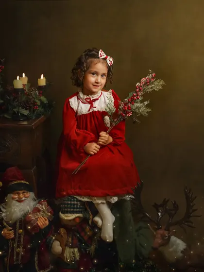 A little girl in a beautiful red velvet dress, holding a sprig of holly. This image has a timeless, nostalgic feel that reminds me of my own childhood Christmases.