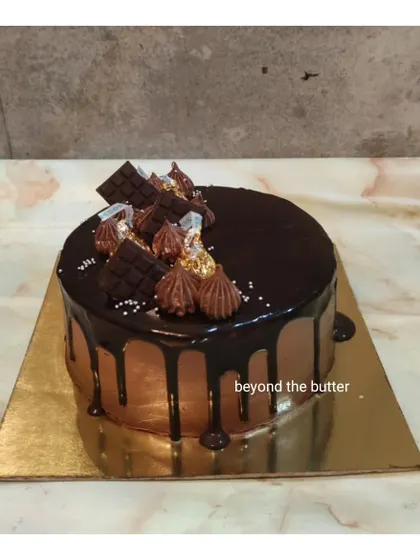 A classic chocolate drip cake topped with Hershey's Kisses and chocolate chunks. A simple, delicious, and timeless choice.