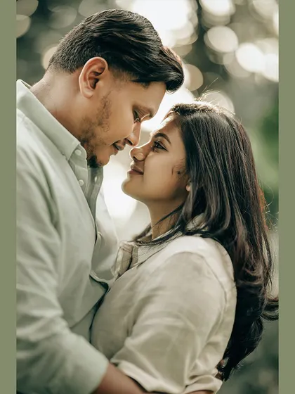 An intimate close-up of a couple, framed in a soft green border, highlighting their loving gaze.