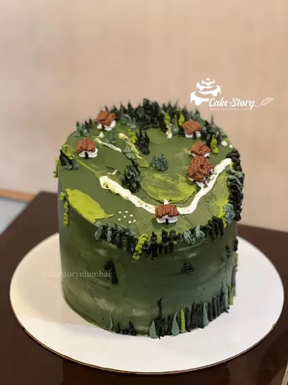 An army-themed cake with a camouflage green frosting. The top is designed to look like a landscape with small houses and trees, perfect for a soldier.