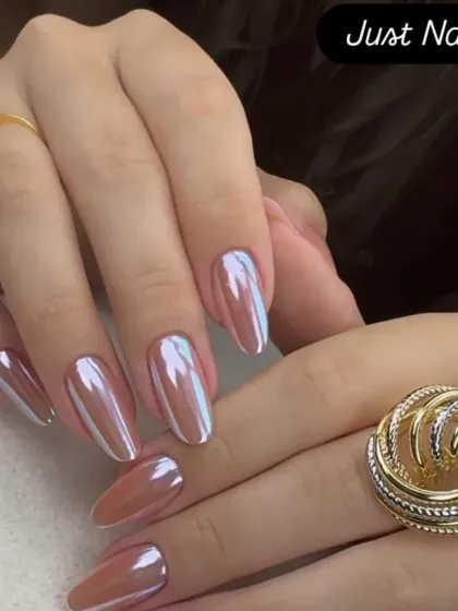 A chic and trendy look featuring a pearlescent chrome finish on medium-length almond nails. The color shifts beautifully in the light.