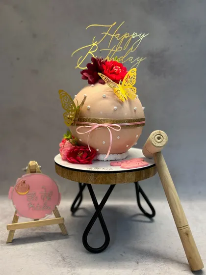 This is my bombshell piñata cake, a chocolate sphere that you get to smash open with a hammer. It's filled with chocolates and other surprises, making it a fun and interactive dessert for any party.