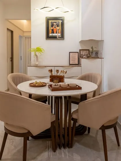 The dining area features a round Italian marble table and cappuccino-toned chairs, creating an elegant and organized space for family meals.