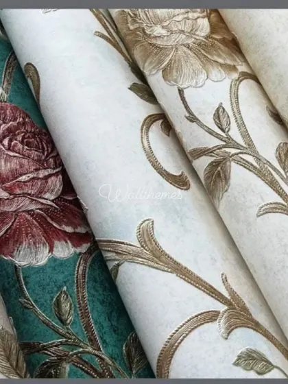 A close-up of several classic rose-patterned wallpaper rolls in different colors.
