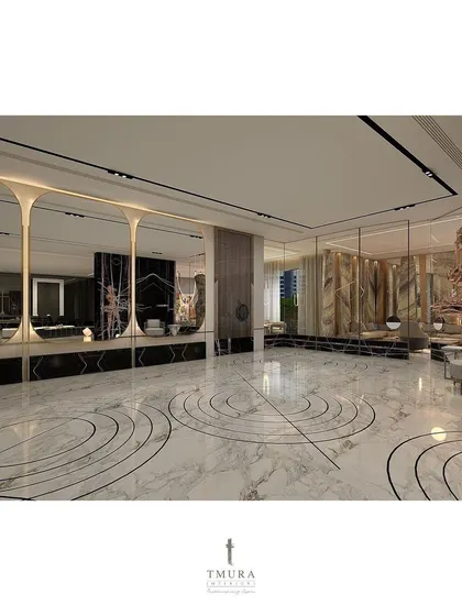 Another view of the grand foyer, highlighting the reflective black marble wall and oversized mirrors that amplify the sense of space. A large, organic sculpture provides a counterpoint to the geometric floor pattern.