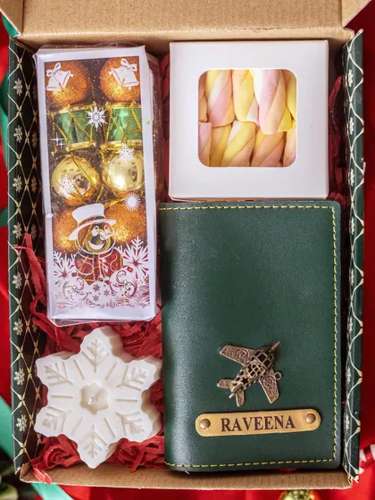 This Christmas hamper is perfect for the traveler in your life. It features a personalized green passport cover, along with festive chocolates and a snowflake-shaped candle.