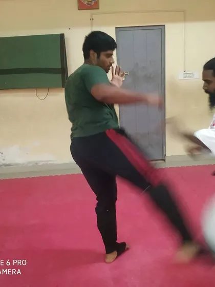 A student executes a front kick while I observe their form. Proper technique ensures maximum impact and stability during a self-defense encounter.