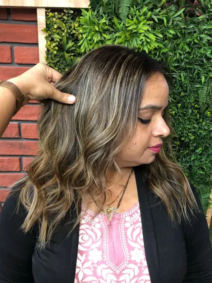 A beautiful blonde balayage that brightens up the client's look. The highlights are expertly blended for a natural, sun-kissed finish.