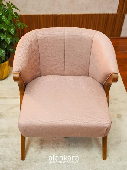 A front view of the Y-Chair, revealing its comfortable, curved back and elegant, tapered legs. The soft pink fabric adds a touch of warmth and sophistication.