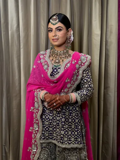 A full-length shot of the bride, her hair in a neat bun complementing her regal outfit.