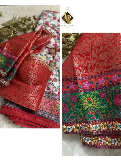 A beautiful blouse made from a red brocade fabric, paired with a multi-color border saree. The sleeve cuffs are highlighted with a delicate embroidered border.