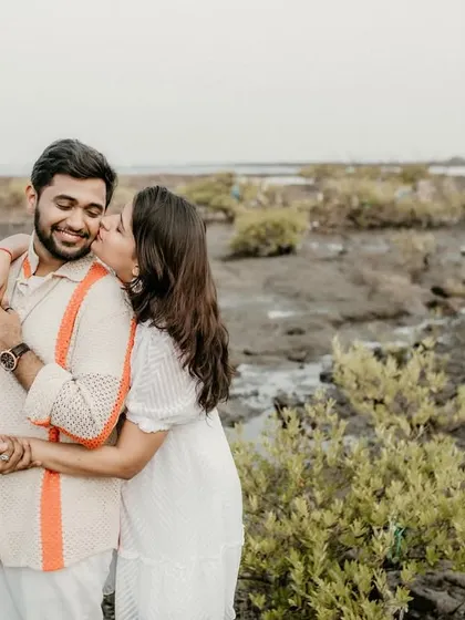 A sweet kiss on the cheek in a unique marshy beach location. This photo shows that beautiful moments can be found in unexpected and rustic settings.