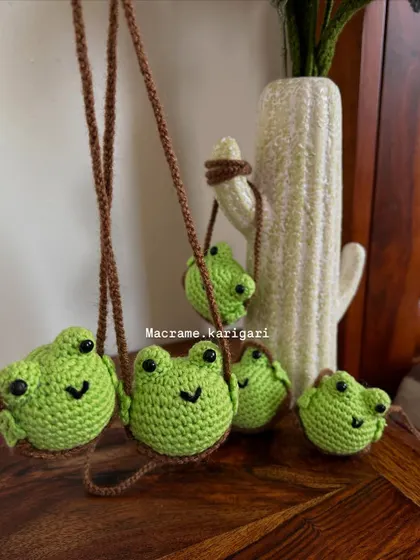 Our family of crochet frog charms. Each one has a sweet, smiling face and is attached to a sturdy cord for hanging. They can also be used as bag charms or home decor.