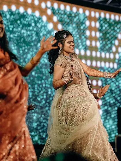 A candid shot of the bride and her bridesmaids mid-performance, all smiles and energy.