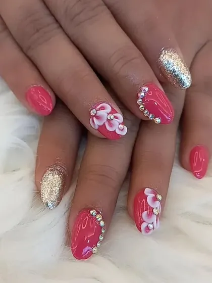 A bright and cheerful design featuring 3D flowers. This set combines a solid pink base with gold glitter accent nails and sculpted flowers, all adorned with rhinestones for extra sparkle.