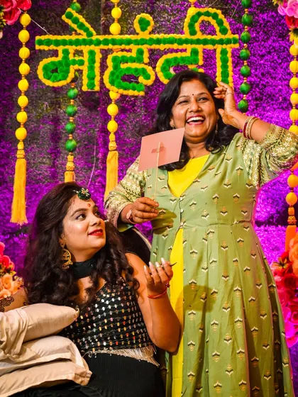 Laughter and candid fun between the bride and a family member at the Mehndi ceremony. It's these genuine, unposed moments that we excel at capturing.