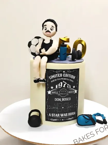 A fun and personalized 50th birthday cake for a fitness enthusiast. The design includes a fondant figure of the birthday person, along with a football, kettlebell, and other gym-related items.