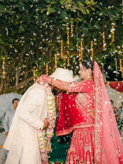 The bride's turn. A joyful shot of the bride placing the garland on the groom during their varmala ceremony.
