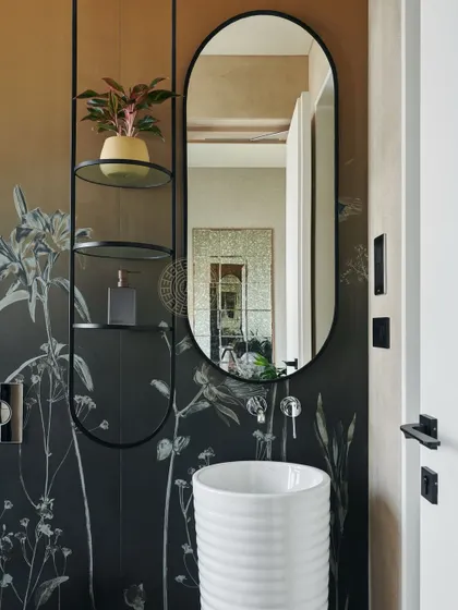 A spa-like bathroom featuring an ombré wallpaper that transitions from dark to light. A minimalist white basin and a sleek shelving unit with a plant add to the serene, artistic feel.