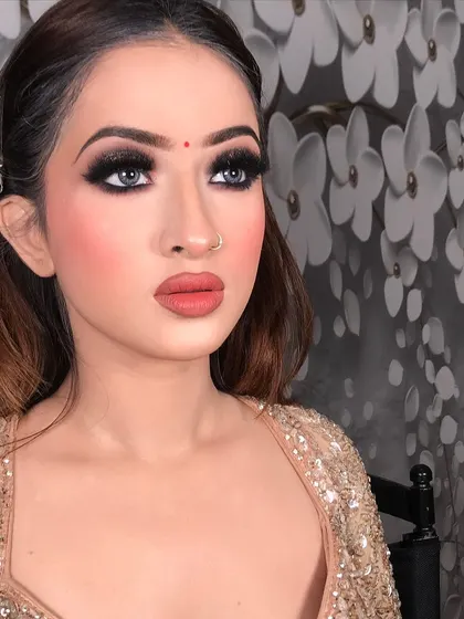 This look is all about the eyes. A classic black smokey eye with sharp liner and full lashes, paired with a matte nude-pink lipstick. This is a timeless party look that suits any glamorous occasion.